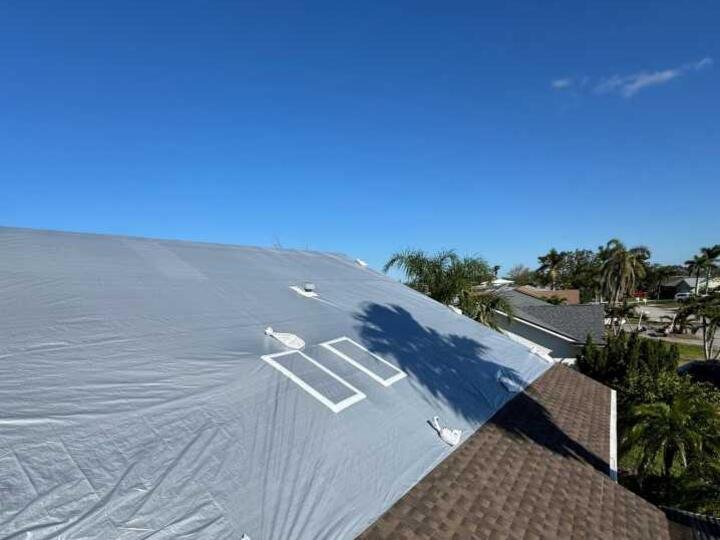 Gray roof tarp secured with sandbags